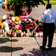 A man stands in front of a tree surrounded by candles and flowers in remembrance of those killed in Buffalo May 14.